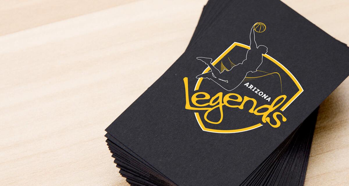 Sports team logo design emblazoned on a stack of party napkins featuring basketball player silhouette dunking over a black and gold shield.