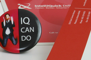 Close up image of a letterhead, info booklet, and promotional button that FabCom developed as part of the corporate identify for a delivery solutions provider.