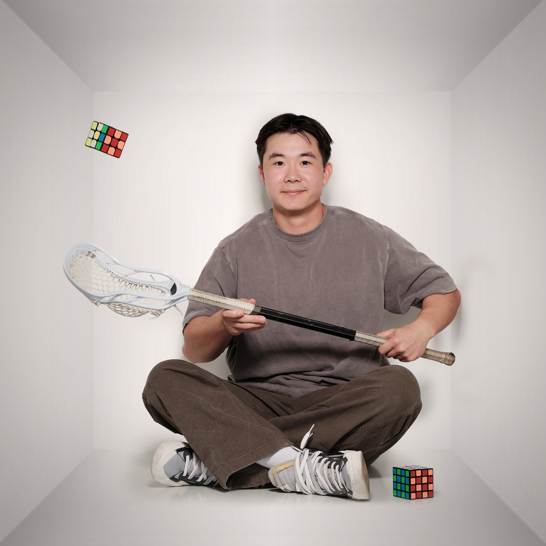Dylan playing with a lacrosse stick and rubix cube