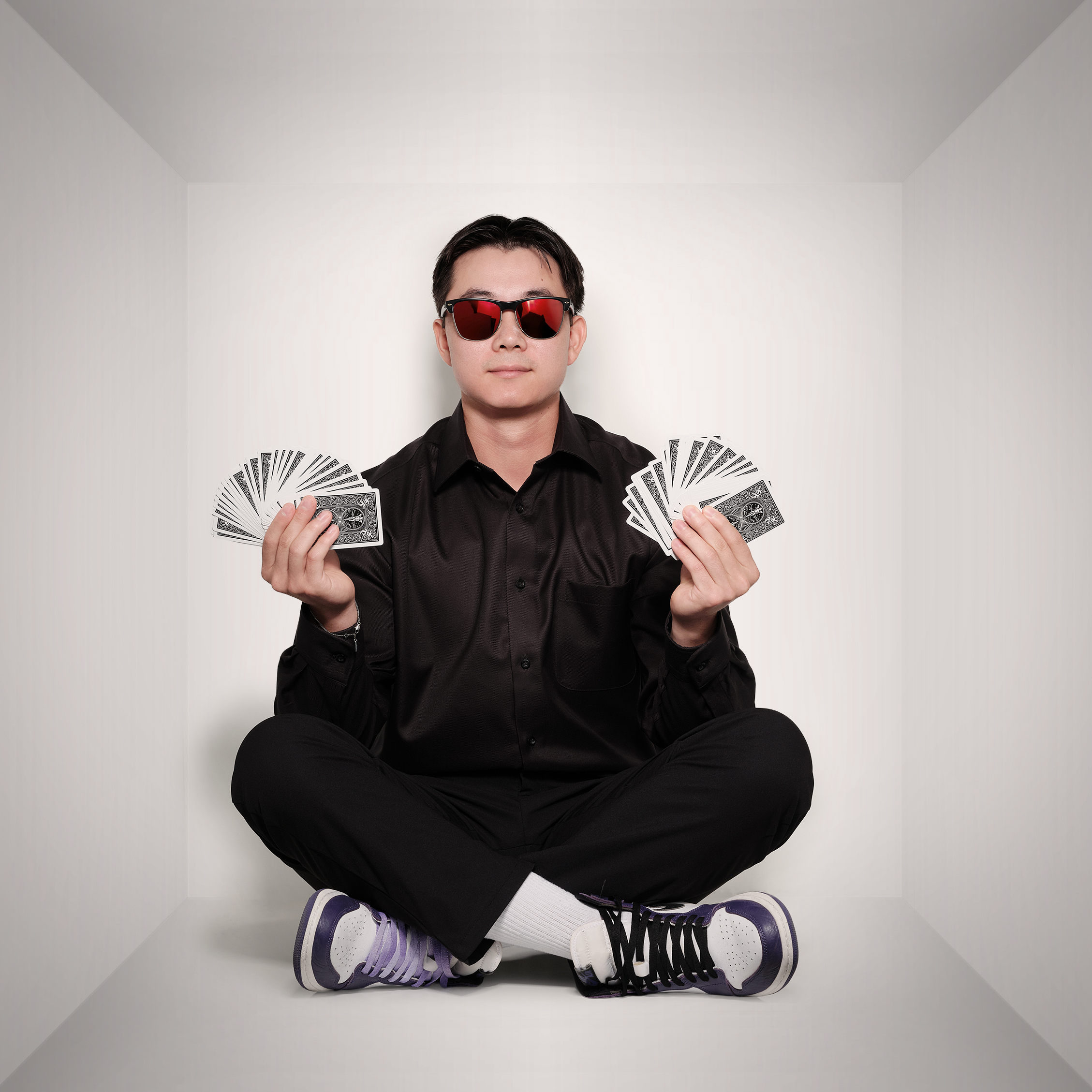 Dylan holding two decks of cards with sunglasses on