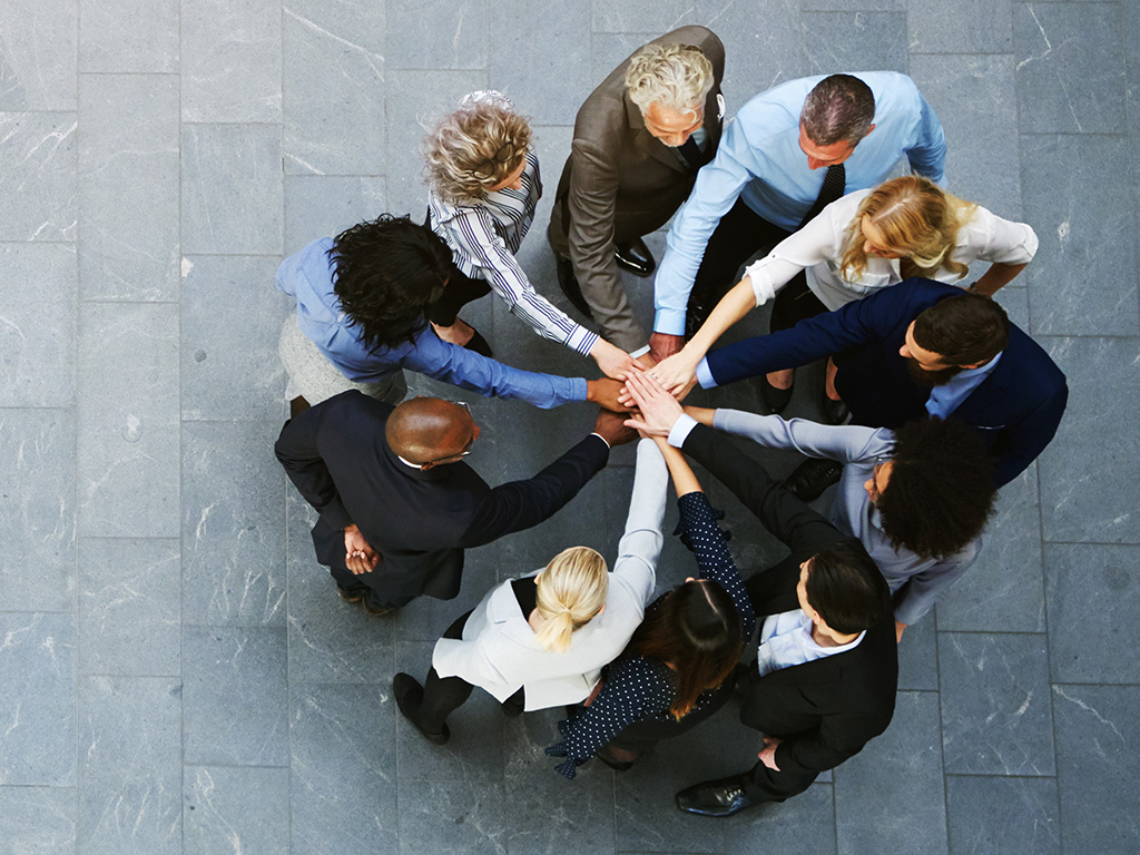 business people with hands in center of huddle