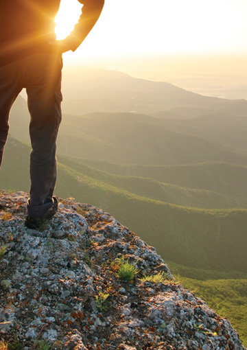 High-resolution zoomed in image showing photographic detail and color quality within a microsite that FabCom developed for a university. Photo features a man standing on rock overlooking a mountainous landscape.