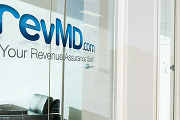 Image of revMD.com logo featured on the glass door to an office.