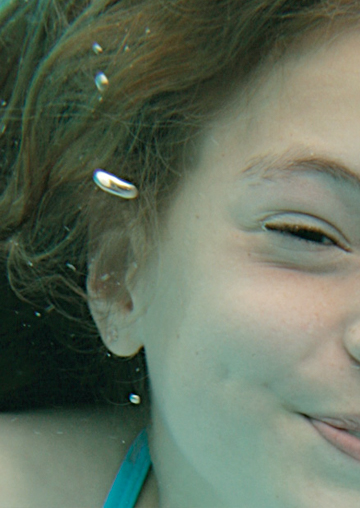 High-resolution zoomed-in image showing photographic detail of a web page FabCom developed. Image shows a young girl swimming under water.