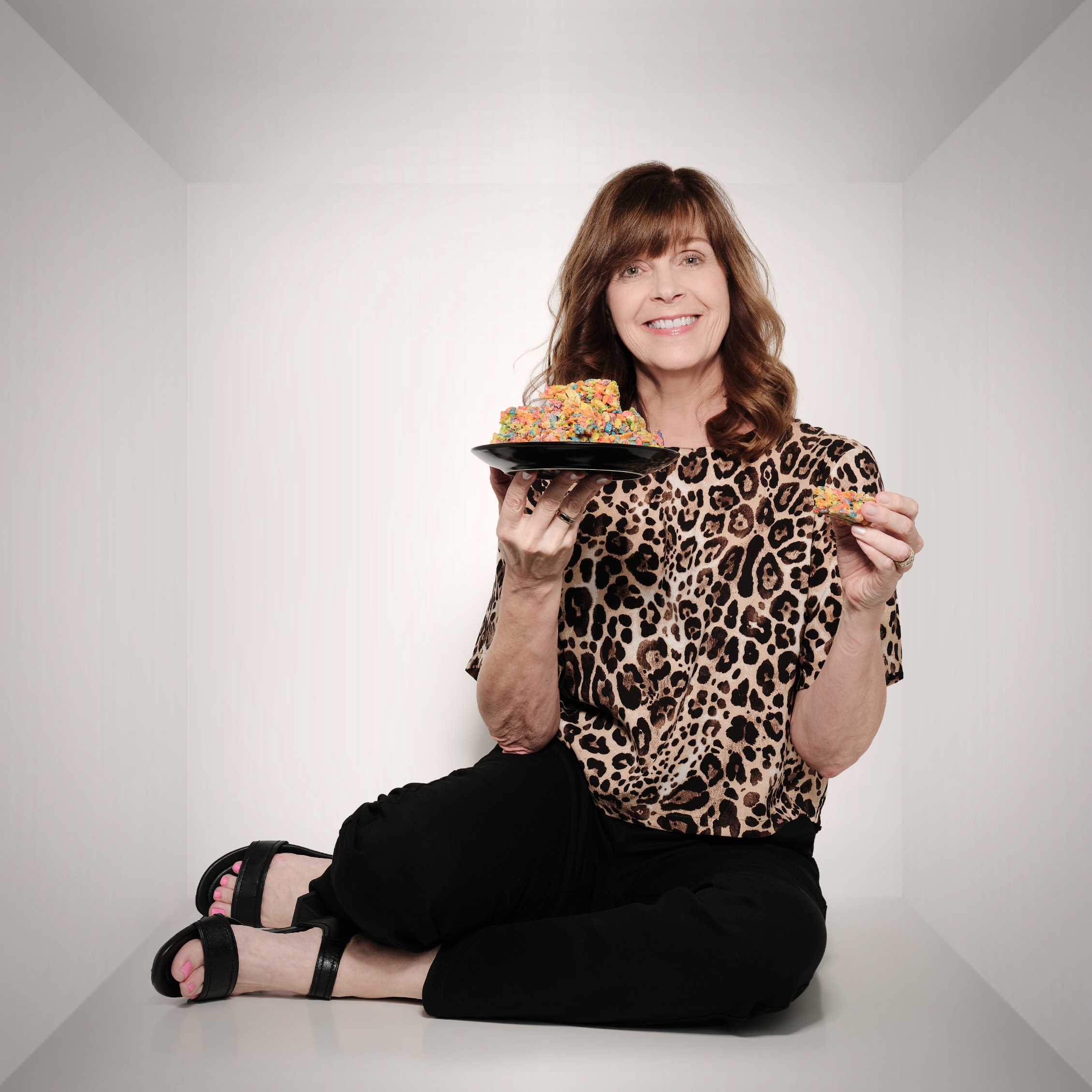 Jennifer holding a plate of food and laughing