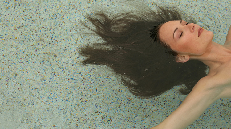 Close up image showing design detail of an image that appears on the International Pool Finish Company website featuring a woman relaxingly floating in a swimming pool.