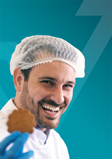 Smiling kitchen worker holding cookie